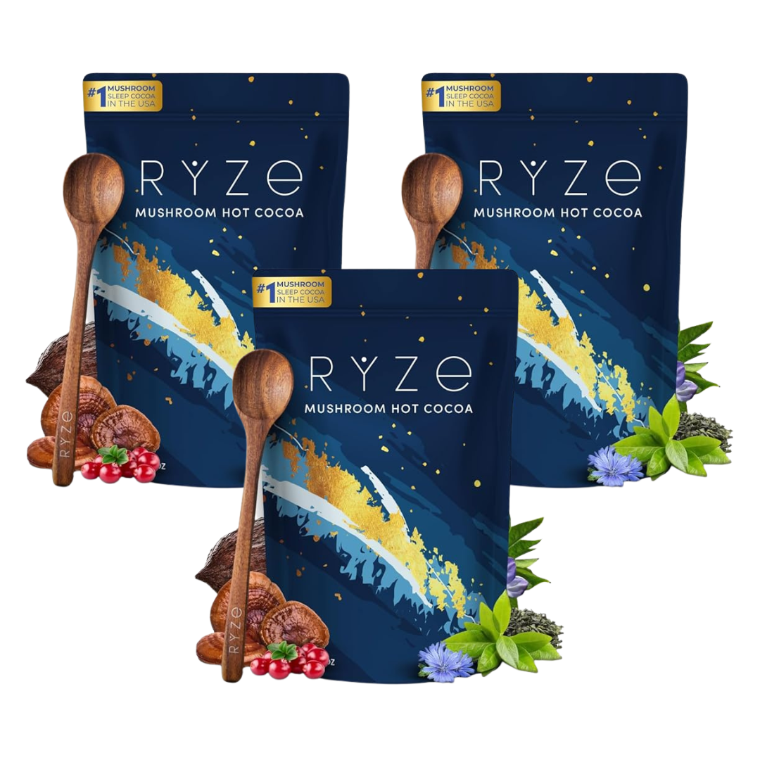 Three bags of RYZE Mushroom Hot Cocoa arranged together on a white background, each package in dark navy blue with gold, white, and light blue abstract brushstroke graphics, plus wooden spoons and small cocoa and berry props.